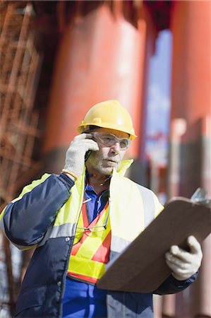 Travailleur parlait au téléphone portable sur la plate-forme de forage pétrolier Photographie de stock - Premium Libres de Droits, Code: 649-04827673