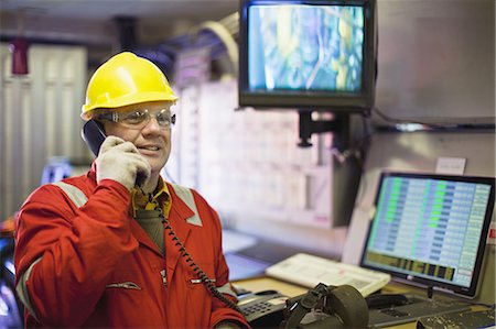 Travailleur parlait au téléphone dans la salle de contrôle Photographie de stock - Premium Libres de Droits, Code: 649-04827686