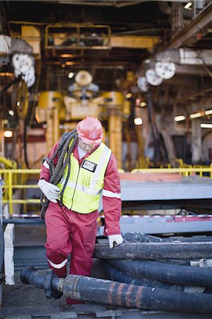 pipe oil - Worker carrying rope on oil rig Stock Photo - Premium Royalty-Free, Code: 649-04827681