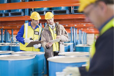 Workers reading clipboards in warehouse Foto de stock - Sin royalties Premium, Código: 649-04827753