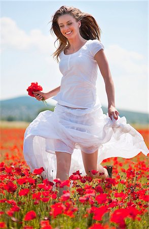 Femme qui marche dans le champ de fleurs Photographie de stock - Premium Libres de Droits, Code: 649-04827994