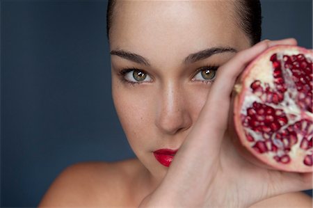 fruit studio white background focus - Woman holding halved pomegranate Stock Photo - Premium Royalty-Free, Code: 649-05520808