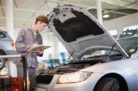 simsearch:6113-09111845,k - Mechanic examining car engine in garage Stock Photo - Premium Royalty-Free, Code: 649-05521239