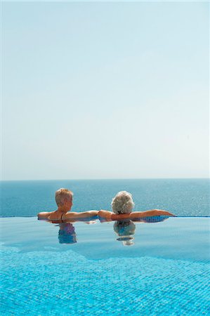 piscina desbordante - Older couple relaxing in infinity pool Foto de stock - Sin royalties Premium, Código: 649-05521397