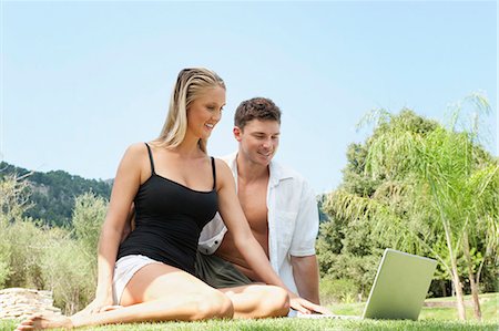 simsearch:6122-08229708,k - Couple using laptop in grass together Stock Photo - Premium Royalty-Free, Code: 649-05521398
