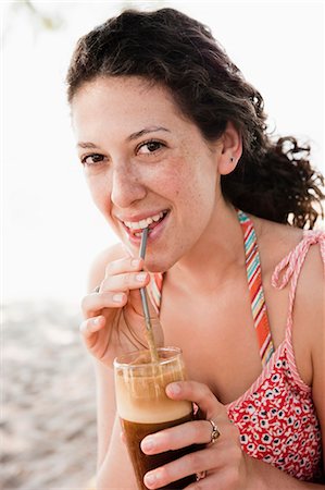 straw beach - Smiling woman drinking through straw Stock Photo - Premium Royalty-Free, Code: 649-05521435