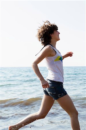 Woman running in waves on beach Stock Photo - Premium Royalty-Free, Code: 649-05521444