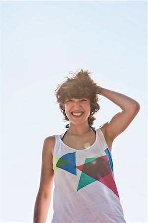 everyday people - Woman smiling against blue sky Stock Photo - Premium Royalty-Free, Code: 649-05521448