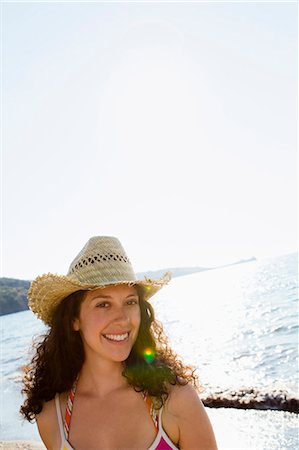Smiling woman wearing sunhat on beach Stock Photo - Premium Royalty-Free, Code: 649-05521459