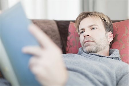 simsearch:649-05521562,k - Man reading book on couch Stock Photo - Premium Royalty-Free, Code: 649-05521602