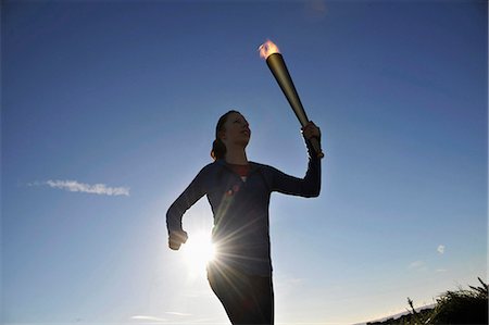 runner from below - Athlete running with flaming baton Stock Photo - Premium Royalty-Free, Code: 649-05522049