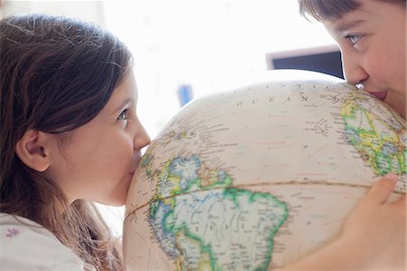 Smiling girls kissing globe indoors Stock Photo - Premium Royalty-Free, Code: 649-05555578