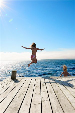 Teenage girls jumping into lake Foto de stock - Sin royalties Premium, Código: 649-05555993