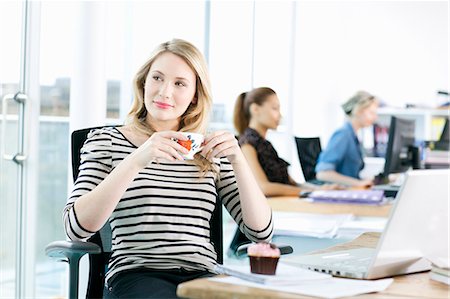 Businesswoman drinking coffee at desk Foto de stock - Sin royalties Premium, Código: 649-05556343