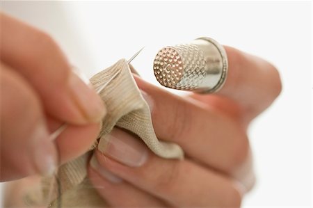 Close up of woman sewing with thimble Stock Photo - Premium Royalty-Free, Code: 649-05648790