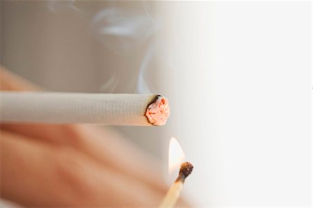 smoking (human activity) - Close up of woman lighting cigarette Stock Photo - Premium Royalty-Free, Code: 649-05648809