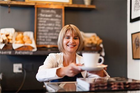 Woman serving coffee in cafe Foto de stock - Sin royalties Premium, Código: 649-05648981