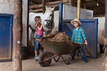 stabil - Boy pushing wheelbarrow in stable Foto de stock - Sin royalties Premium, Código: 649-05649034