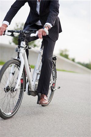 simsearch:693-06403501,k - Businessman riding bicycle in urban park Stock Photo - Premium Royalty-Free, Code: 649-05649143