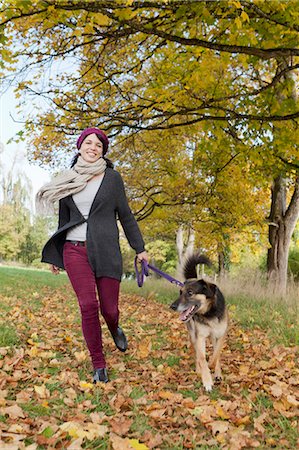 dog people run - Smiling woman walking dog in park Stock Photo - Premium Royalty-Free, Code: 649-05649608