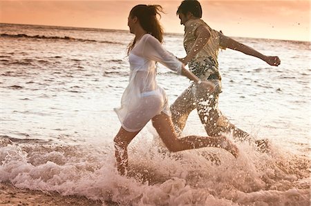 Couple en cours d'exécution dans les vagues à la plage Photographie de stock - Premium Libres de Droits, Code: 649-05649898