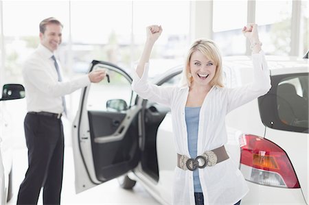 salesman with customer - Woman cheering in car dealership Foto de stock - Sin royalties Premium, Código: 649-05656604