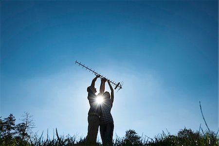 Couple holding up antenna outdoors Stock Photo - Premium Royalty-Free, Code: 649-05656922