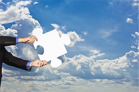 Businessman holding puzzle piece Stock Photo - Premium Royalty-Free, Code: 649-05657048