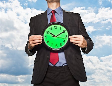 performance concept - Businessman holding clock Stock Photo - Premium Royalty-Free, Code: 649-05657041