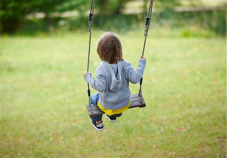 swing outdoor - Children sitting in swing in backyard Stock Photo - Premium Royalty-Free, Code: 649-05657087