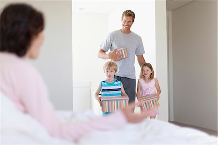 delighted gift not christmas - Family bringing mother presents in bed Stock Photo - Premium Royalty-Free, Code: 649-05657156