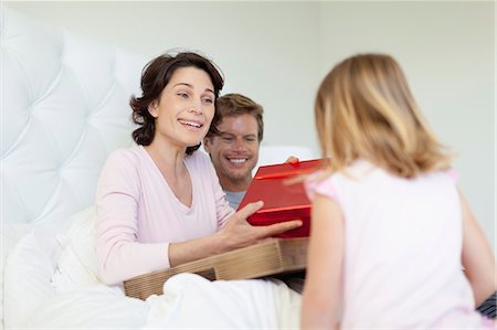 seated girl back view - Family bringing mother presents in bed Stock Photo - Premium Royalty-Free, Code: 649-05657161