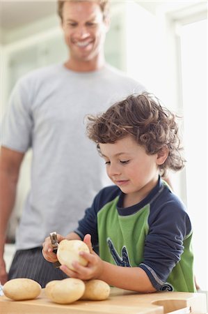 pelar - Boy peeling potatoes in kitchen Foto de stock - Sin royalties Premium, Código: 649-05657176