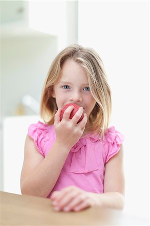 Girl eating apple in kitchen Foto de stock - Royalty Free Premium, Número: 649-05657181