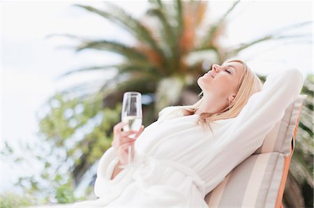 Woman in bathrobe relaxing in lawn chair Stock Photo - Premium Royalty-Free, Code: 649-05657273