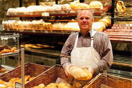 depósito - Smiling baker holding loaf of bread Foto de stock - Sin royalties Premium, Código: 649-05657459