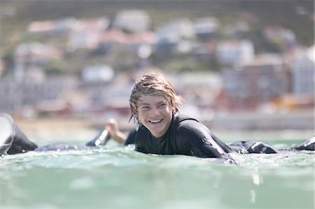 roupa molhada - Teenage boy paddling with surfboard Foto de stock - Royalty Free Premium, Número: 649-05657495