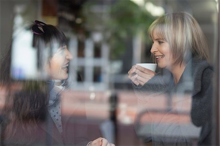 Smiling women having coffee in cafe Foto de stock - Sin royalties Premium, Código: 649-05657517