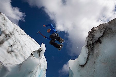 Hiker jumping in between glaciers Stock Photo - Premium Royalty-Free, Code: 649-05657619