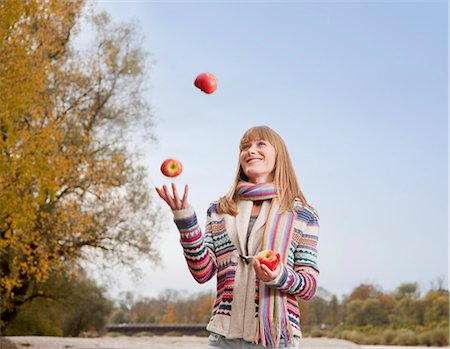 Woman juggling apples outdoors Foto de stock - Royalty Free Premium, Número: 649-05657700