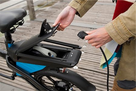 Woman charging electric bike outdoors Stock Photo - Premium Royalty-Free, Code: 649-05657711