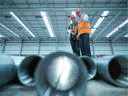 satisfacción - Workers examining pipes in warehouse Foto de stock - Sin royalties Premium, Código: 649-05657970
