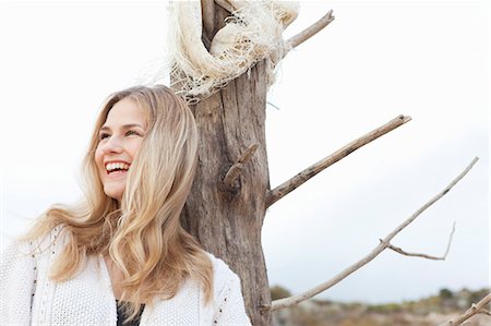 Smiling woman leaning against tree Stock Photo - Premium Royalty-Free, Code: 649-05658236