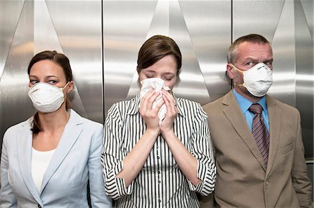 prevención - Woman coughing around others in elevator Foto de stock - Sin royalties Premium, Código: 649-05658250