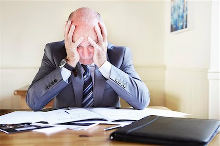 Businessman reading notes at desk Stock Photo - Premium Royalty-Free, Code: 649-05800858