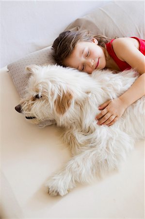 pet and children - Girl relaxing with dog in bed Stock Photo - Premium Royalty-Free, Code: 649-05800974