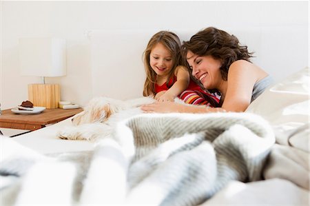 Mother and daughter in bed with dog Foto de stock - Sin royalties Premium, Código: 649-05801031