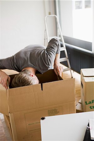 Man searching cardboard boxes Stock Photo - Premium Royalty-Free, Code: 649-05801097