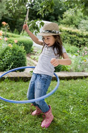 Girl playing with hula hoop in backyard Foto de stock - Sin royalties Premium, Código: 649-05801126