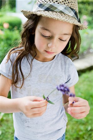 straw hat - Girl examining flower outdoors Stock Photo - Premium Royalty-Free, Code: 649-05801128